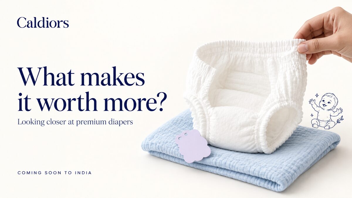 Caldiors 'What makes it worth more?' – a hand lifting the waistband of a premium pant style diaper resting on a folded blue muslin cloth